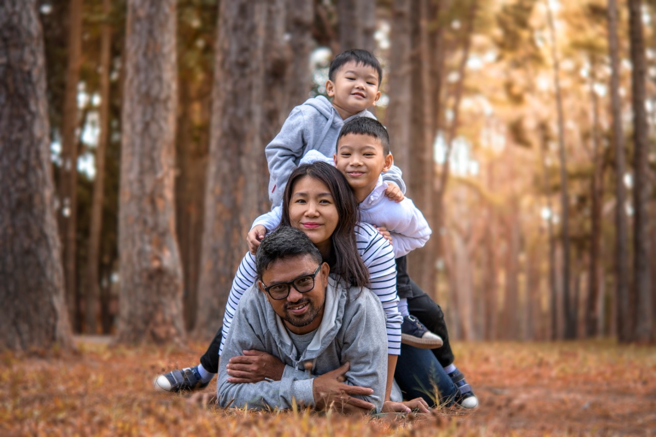 Young family with children having fun in nature, father, mother and children.