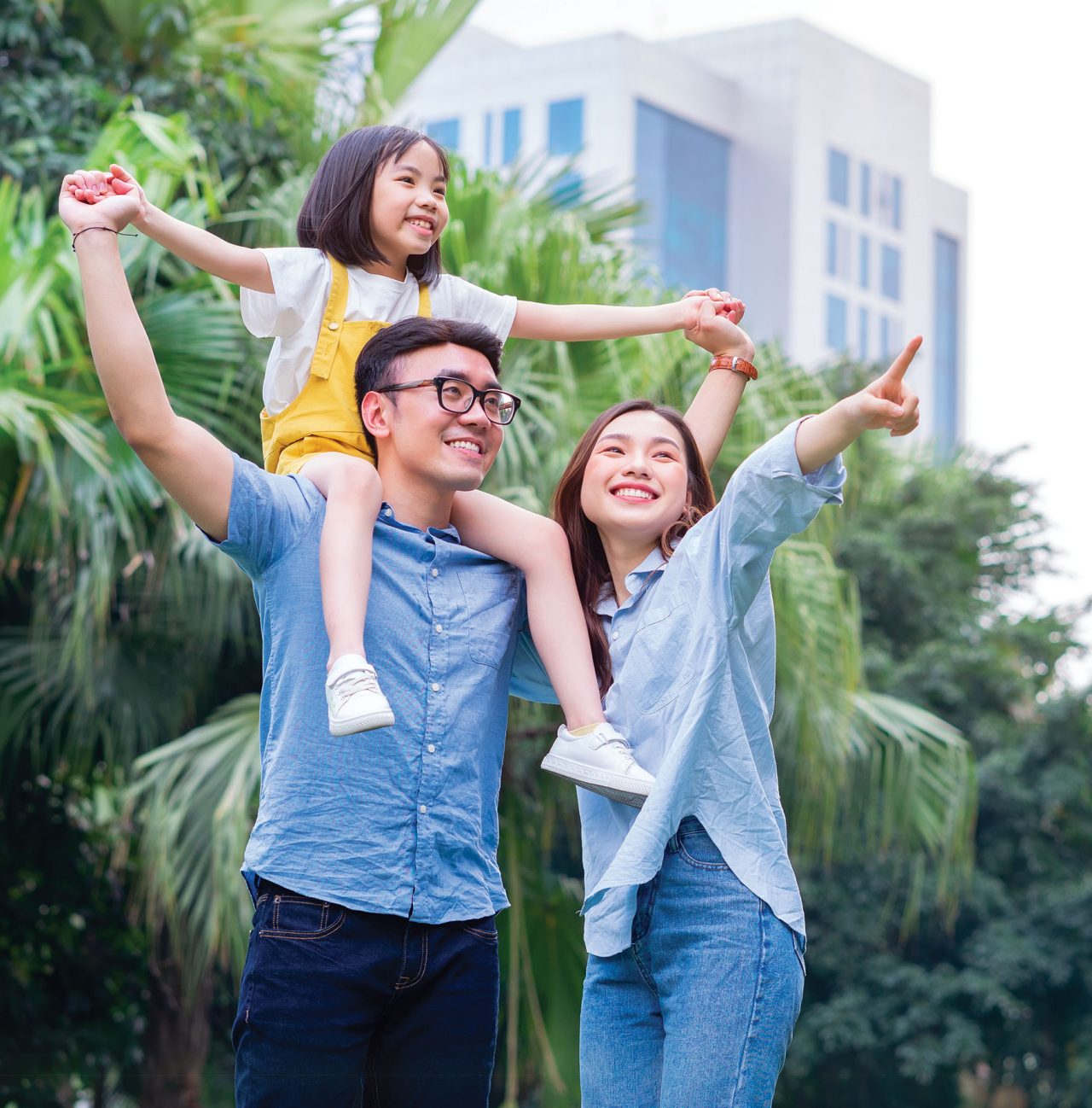 Image of young Asian family playing together at park